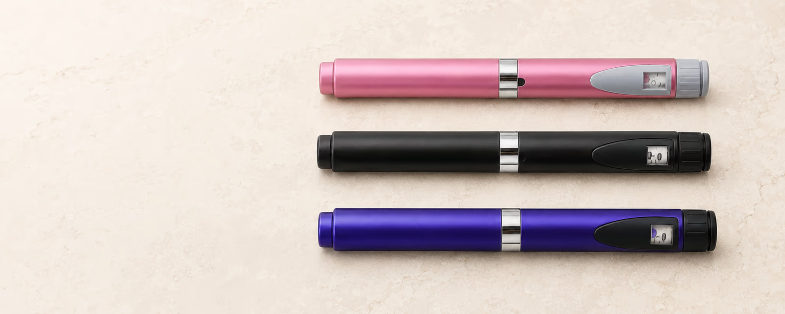 Pink, black and purple reusable pens arranged horizontally